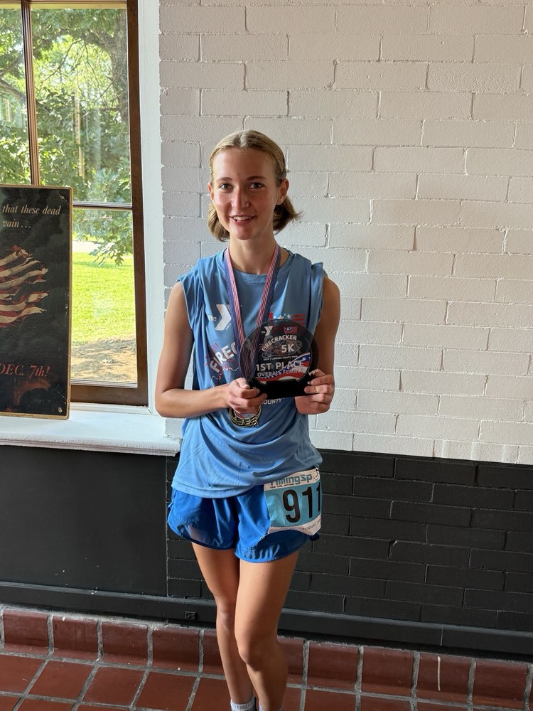Isla Meyn holding the 1st Place Overall Female award at the 2026 Firecracker 5K